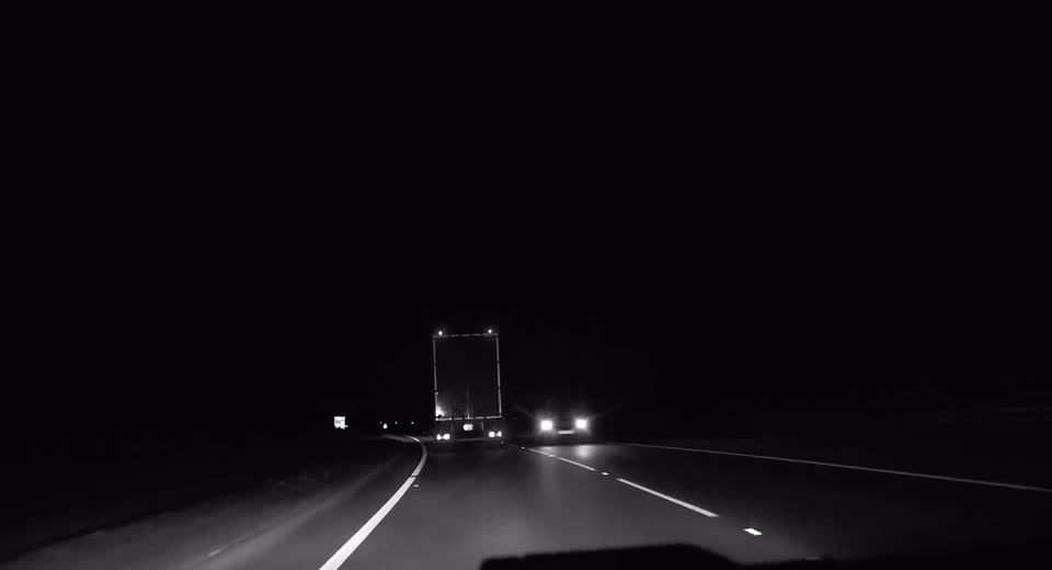 Caminhão em rodovia à noite, visto de trás